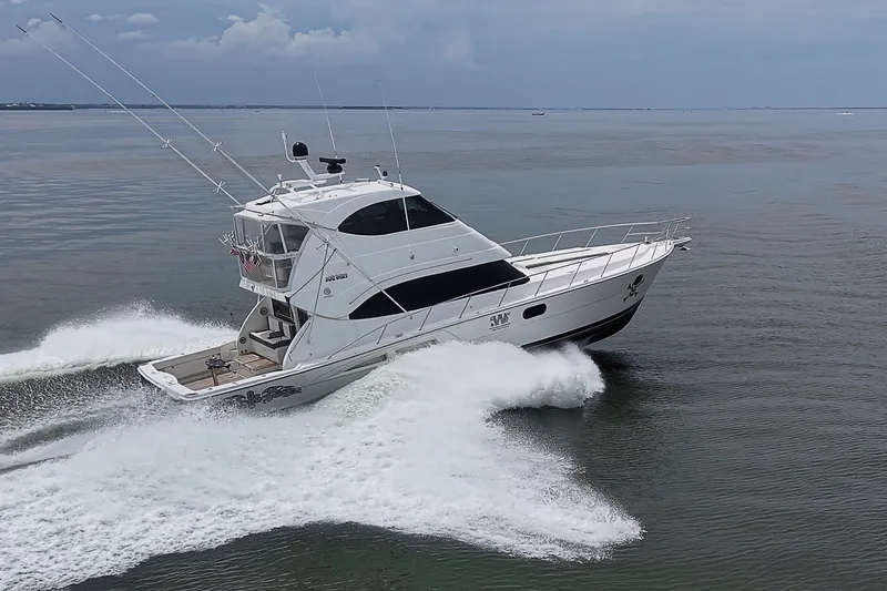 Slide: The Image of 2009 Riviera 58 Flybridge yacht cruising swiftly on open water. - 100