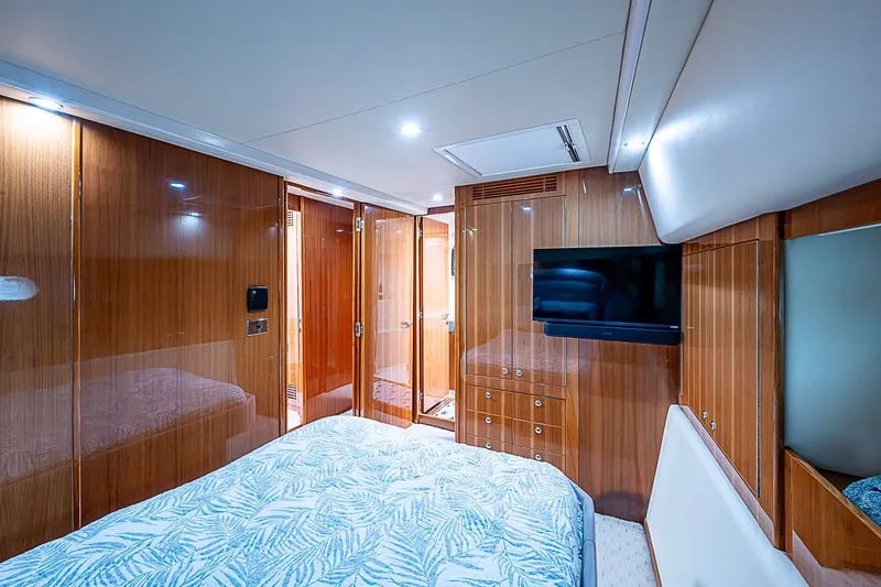 Slide: The Image of Luxurious bedroom interior of 2009 Riviera 58 Flybridge yacht with wood paneling and TV. - 23