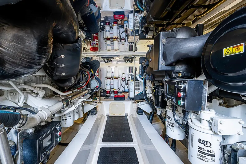 Slide: The Image of Engine room of a 2009 Riviera 58 Flybridge yacht, showcasing mechanical components and systems. - 58