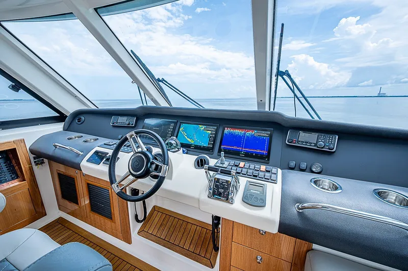 Slide: The Image of Luxurious 2009 Riviera 58 Flybridge yacht helm with advanced navigation systems and panoramic ocean view. - 61