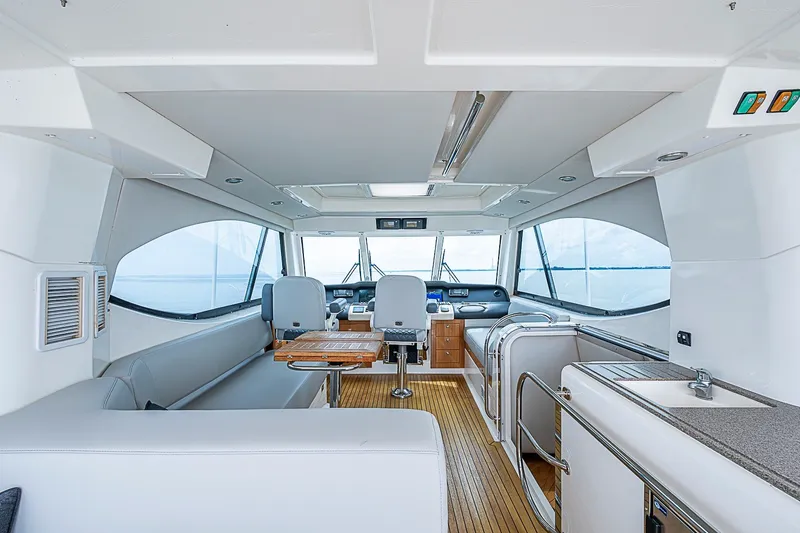 Slide: The Image of Luxurious interior of 2009 Riviera 58 Flybridge yacht with modern seating and navigation area. - 73