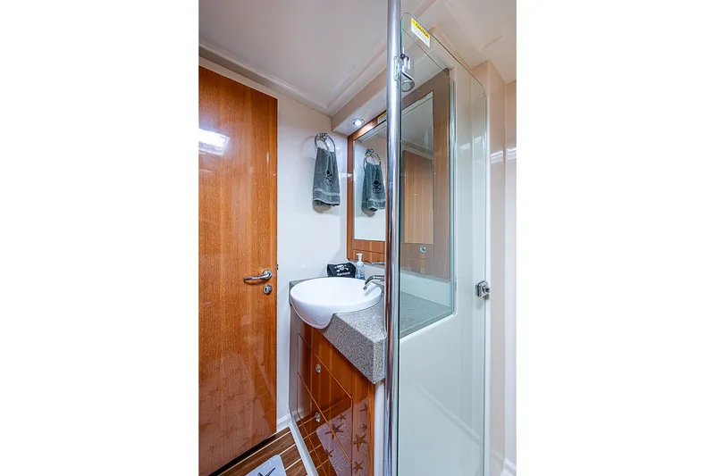 Slide: The Image of Luxurious bathroom in 2009 Riviera 58 Flybridge yacht with modern fixtures and wooden accents. - 34
