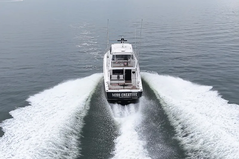 Slide: The Image of 2009 Riviera 58 Flybridge yacht cruising on open water, rear view. - 92