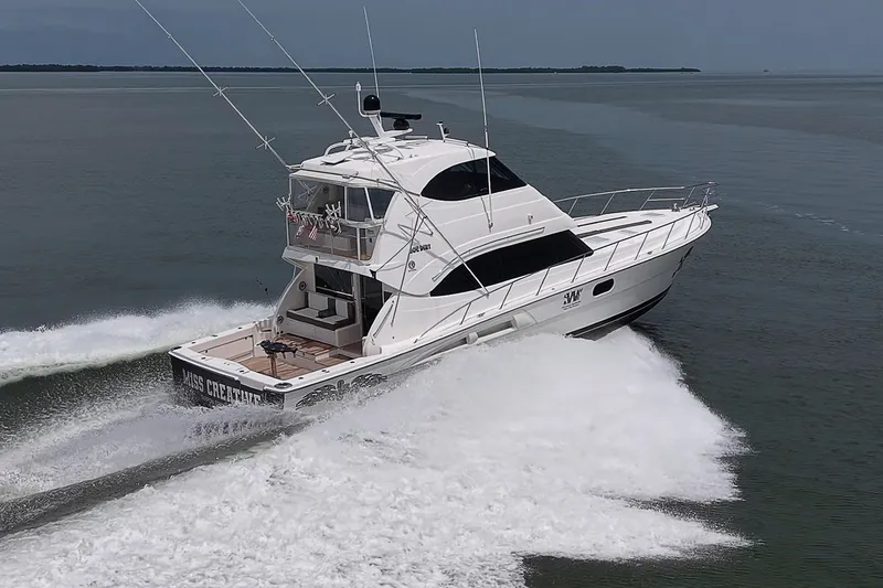 Slide: The Image of 2009 Riviera 58 Flybridge yacht cruising on open water, creating a dynamic wake. - 107