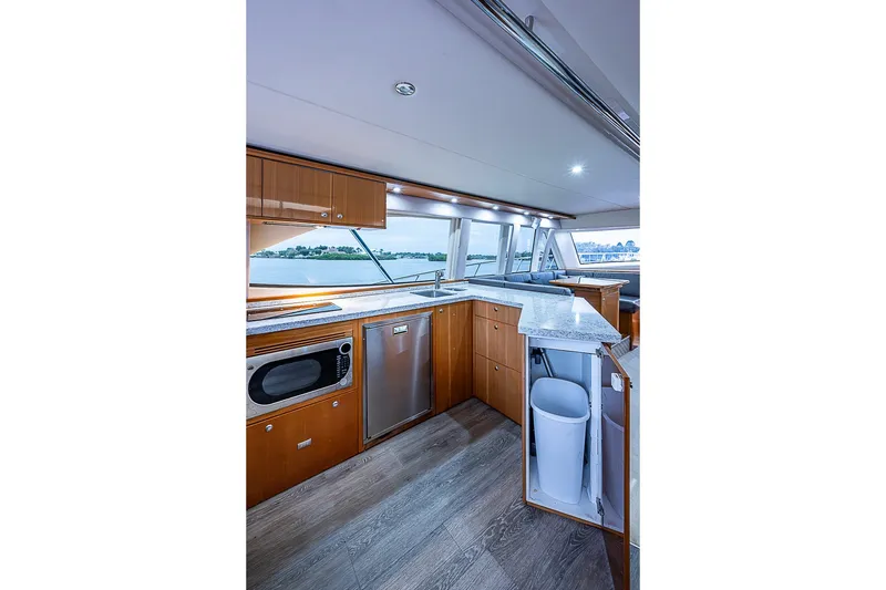 Slide: The Image of Luxurious interior of 2009 Riviera 58 Flybridge yacht with modern kitchen amenities. - 17