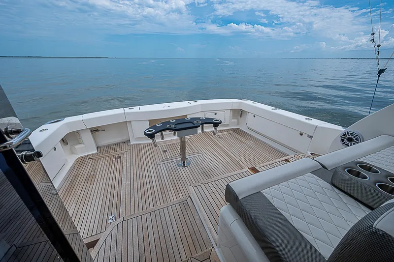 Slide: The Image of 2009 Riviera 58 Flybridge yacht deck with ocean view, featuring spacious seating and elegant wood flooring. - 82