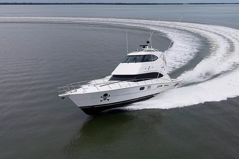 Slide: The Image of 2009 Riviera 58 Flybridge yacht cruising swiftly on open water. - 102