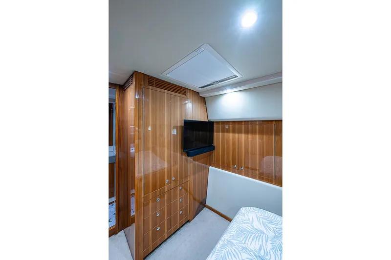Slide: The Image of Luxurious interior of 2009 Riviera 58 Flybridge yacht with wood paneling and mounted TV. - 27