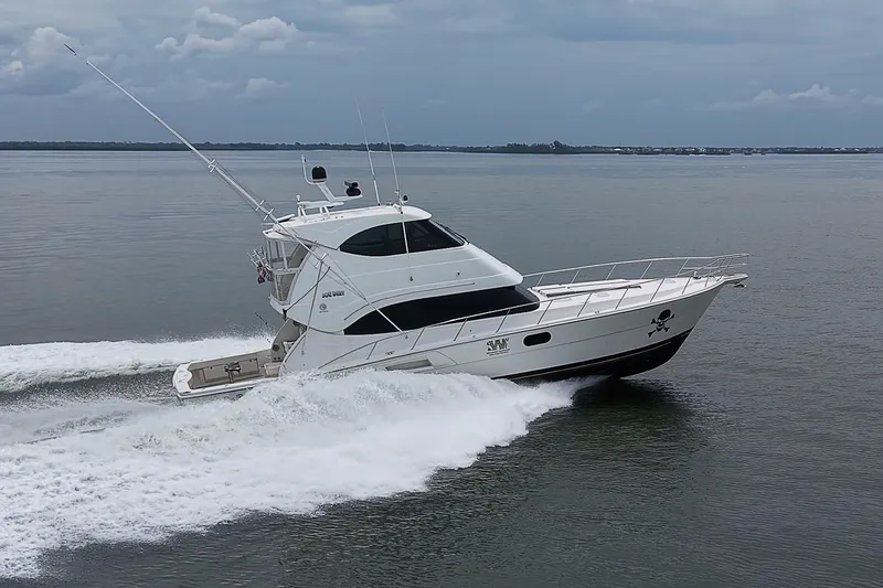 Slide: The Image of 2009 Riviera 58 Flybridge yacht cruising on calm waters under cloudy skies. - 96