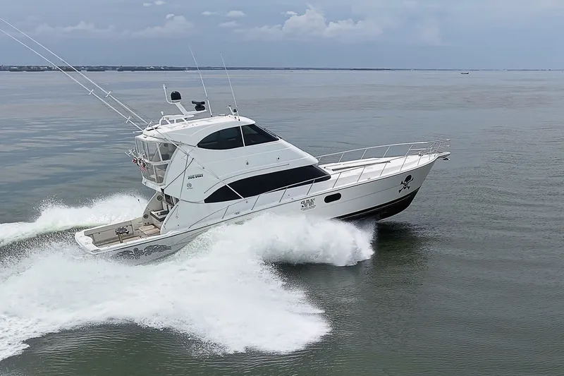 Slide: The Image of 2009 Riviera 58 Flybridge yacht cruising swiftly on open water. - 97