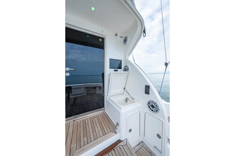 Slide: The Image of 2009 Riviera 58 Flybridge yacht deck with sink and wooden flooring. - 75