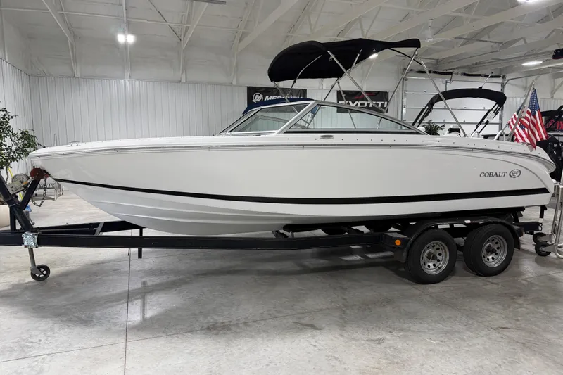 The Image of 2013 Cobalt 220 boat on trailer in indoor showroom setting. - 1