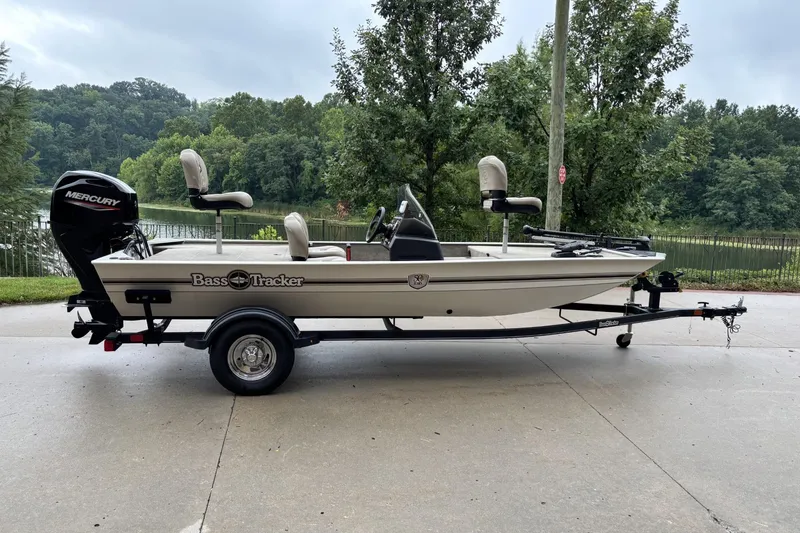 The Image of 2022 Tracker Bass Tracker Classic XL boat on trailer, parked near a scenic lake. - 0