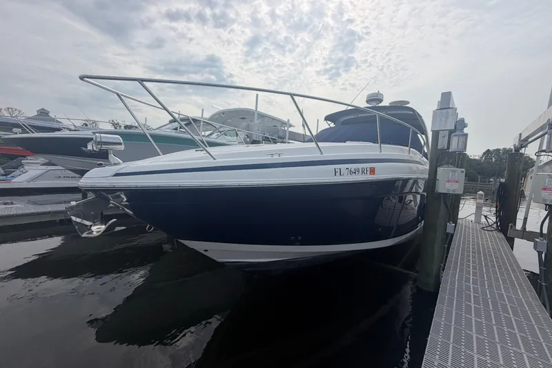 Slide: The Image of 2017 Regal 32 Express boat docked at marina under cloudy sky. - 2