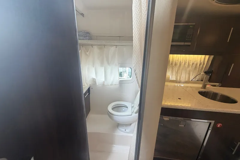 Slide: The Image of 2017 Regal 32 Express yacht interior with bathroom and kitchenette. - 21