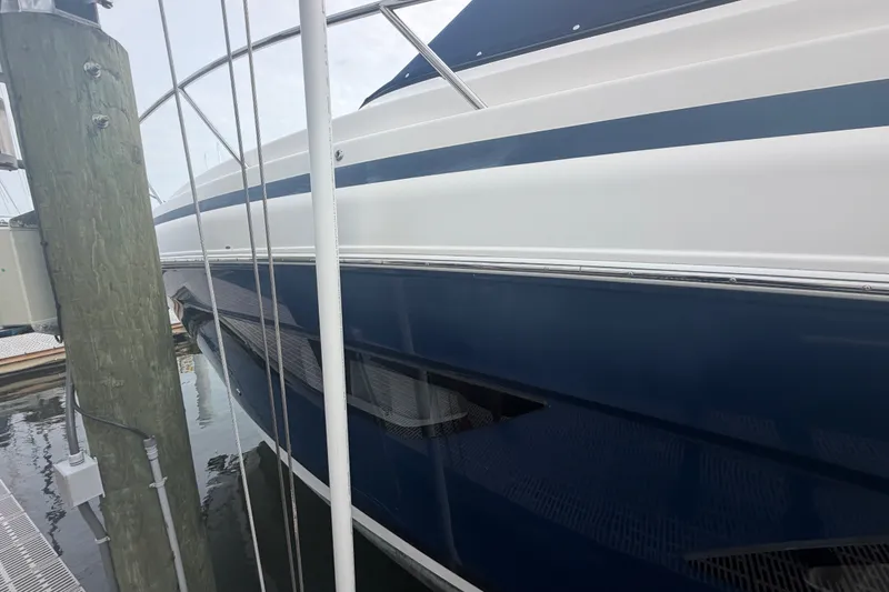 Slide: The Image of 2017 Regal 32 Express boat docked, showcasing sleek blue and white hull design. - 35