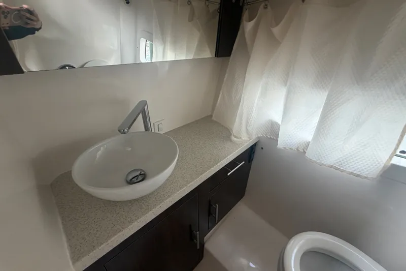 Slide: The Image of Modern bathroom interior on 2017 Regal 32 Express yacht, featuring a sleek sink and countertop. - 22