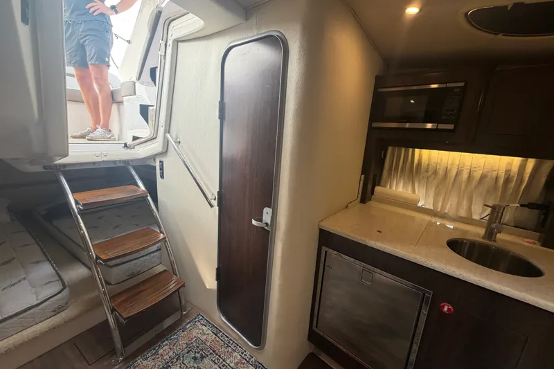 Slide: The Image of Interior of 2017 Regal 32 Express yacht with kitchenette and stairs to deck. - 20