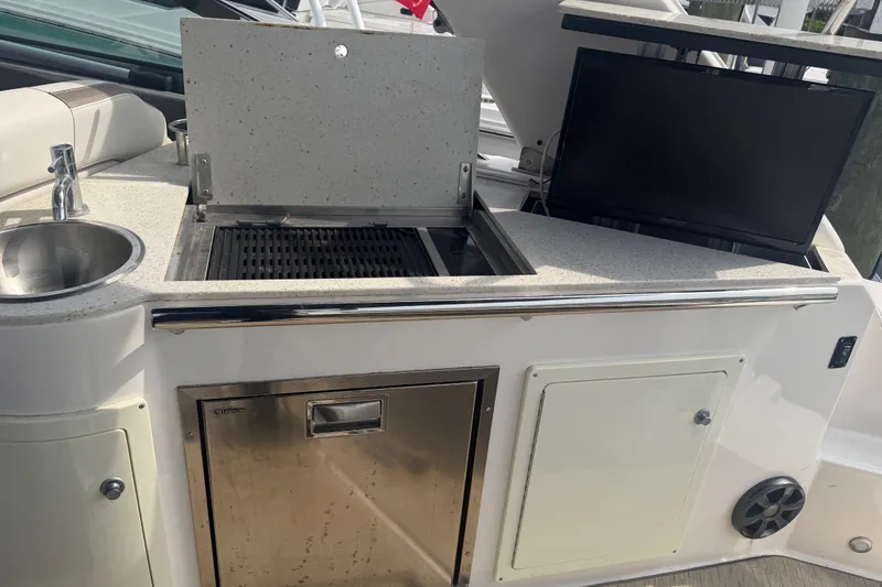 Slide: The Image of Outdoor kitchen on 2017 Regal 32 Express boat with grill, sink, and TV. - 29