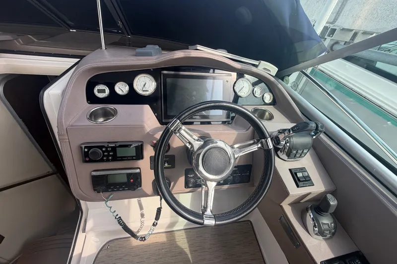Slide: The Image of Cockpit of 2017 Regal 32 Express boat with steering wheel and control panel. - 10
