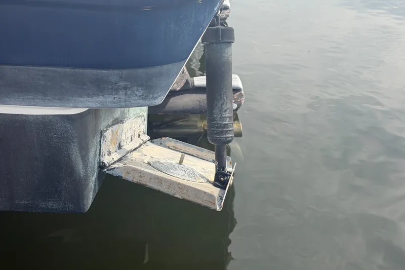 Slide: The Image of 2017 Regal 32 Express boat stern detail with trim tab in water. - 45