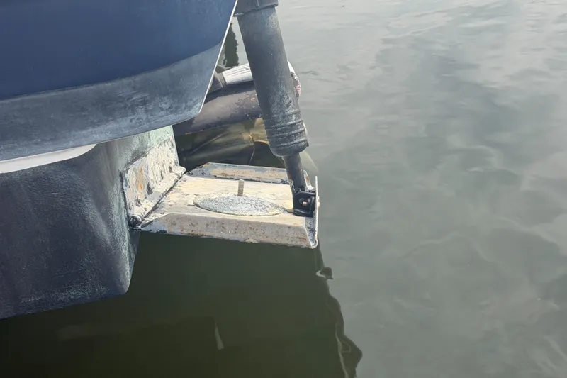 Slide: The Image of 2017 Regal 32 Express boat stern detail with trim tab in water. - 44