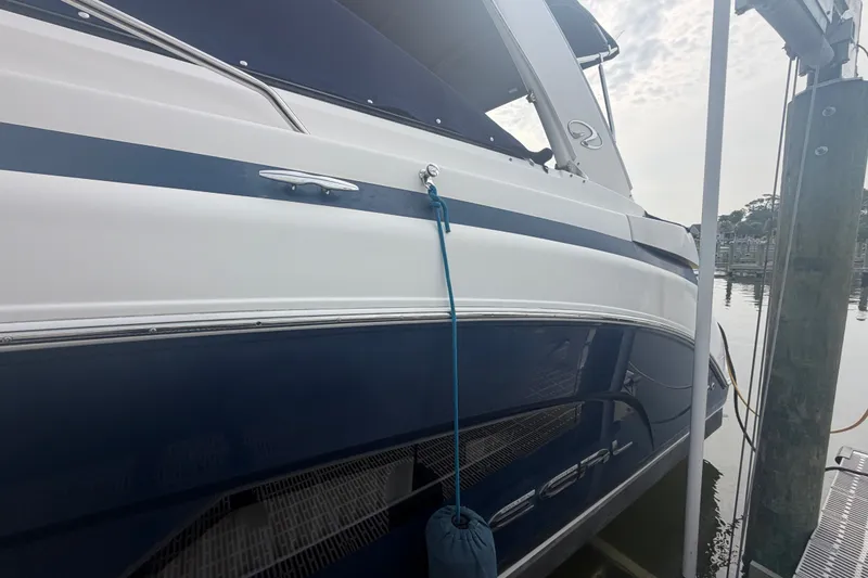 Slide: The Image of 2017 Regal 32 Express boat docked, featuring sleek blue and white design. - 40
