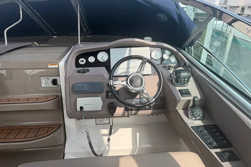 Slide: The Image of Cockpit of 2017 Regal 32 Express boat with steering wheel and navigation controls. - 9