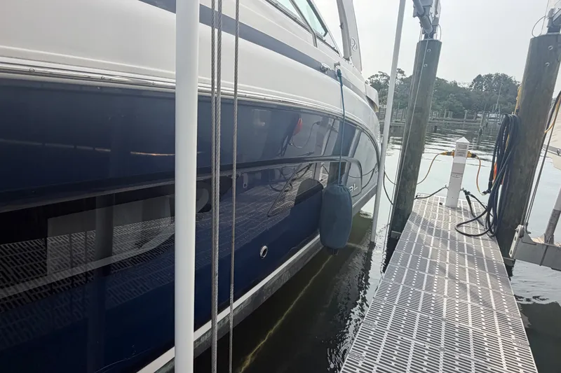 Slide: The Image of 2017 Regal 32 Express yacht docked at marina, side view with reflections on water. - 39