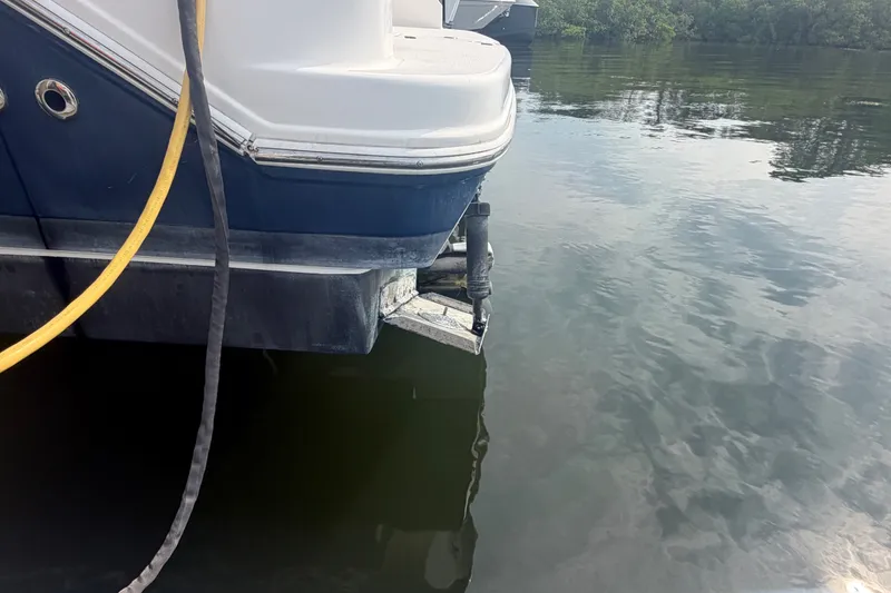Slide: The Image of 2017 Regal 32 Express boat stern in calm water, with visible cables and reflections. - 43