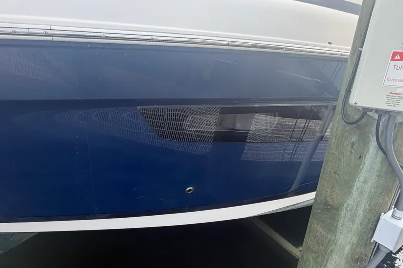 Slide: The Image of 2017 Regal 32 Express boat docked, featuring a sleek blue hull design. - 38