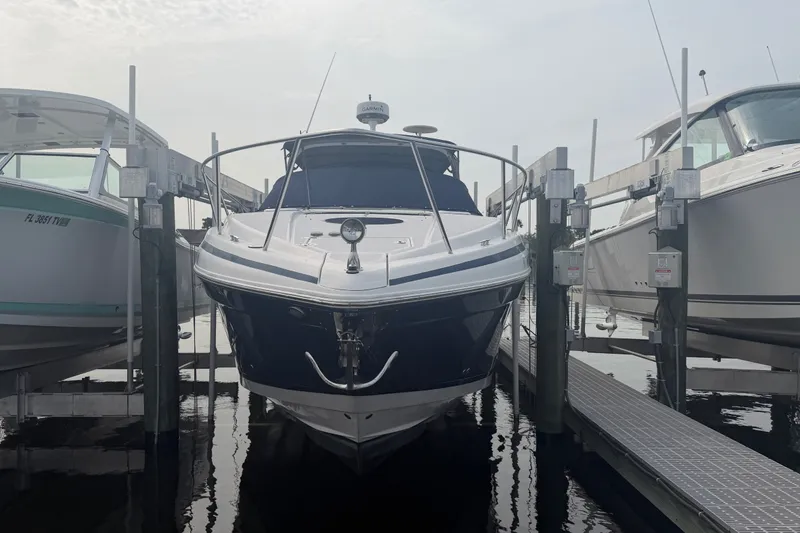 Slide: The Image of 2017 Regal 32 Express boat docked between two others at a marina. - 1