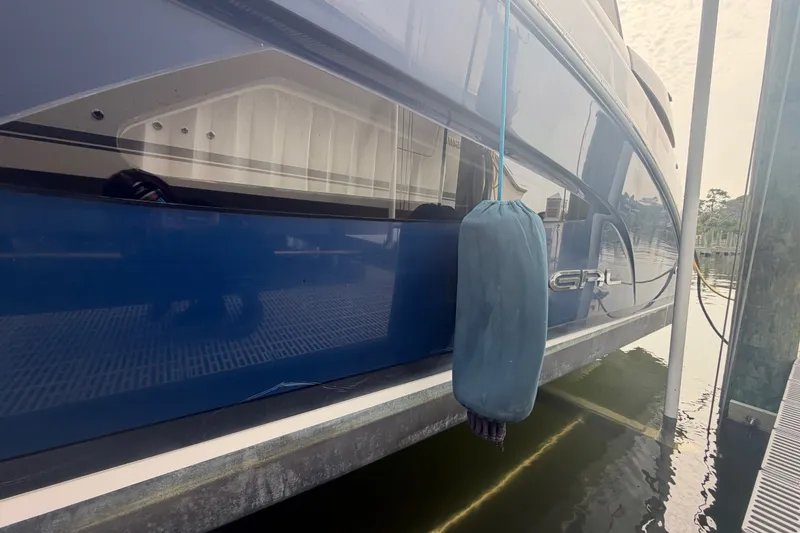 Slide: The Image of 2017 Regal 32 Express boat docked with blue hull and fender. - 41