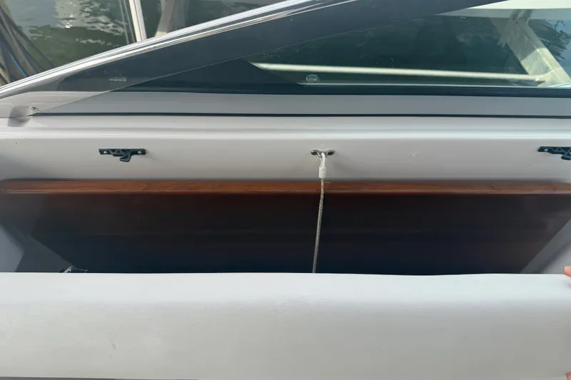 Slide: The Image of A 2017 Regal 32 Express with an open storage compartment and a wooden board inside. - 7