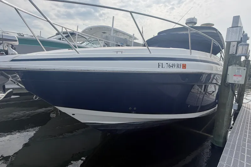 Slide: The Image of 2017 Regal 32 Express boat docked, featuring sleek blue and white design. - 3