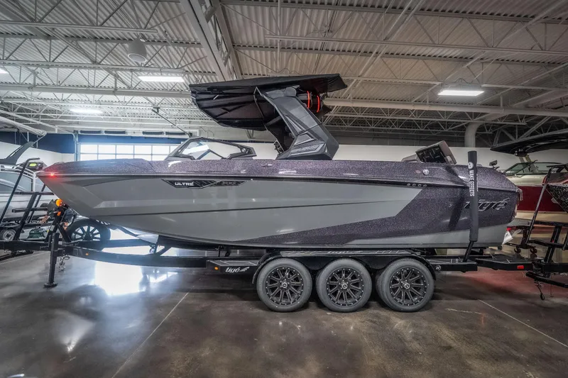 The Image of 2026 Tigé Ultré 25ZX boat on trailer in showroom, showcasing sleek design and modern features. - 1