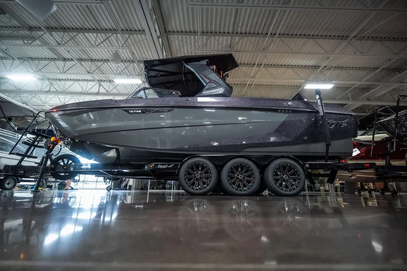 Slide: The Image of 2026 Tigé Ultré 25ZX boat on trailer in showroom, showcasing sleek design and modern features. - 29
