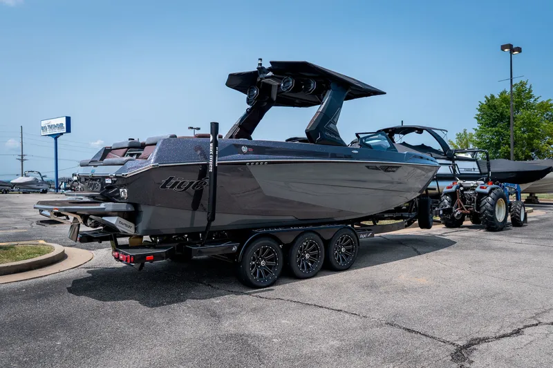 Slide: The Image of 2026 Tigé Ultré 25ZX boat on trailer in parking lot, showcasing sleek design and modern features. - 8