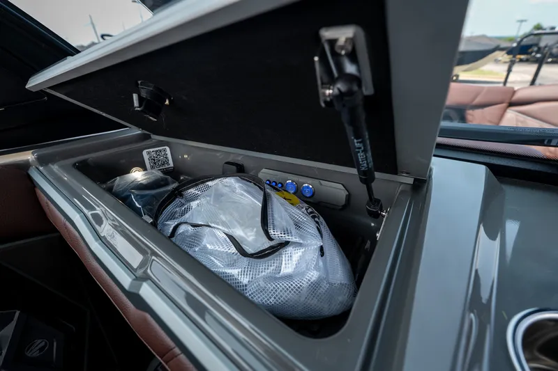 Slide: The Image of Storage compartment of 2026 Tigé Ultré 25ZX boat, featuring organized gear and accessories. - 22