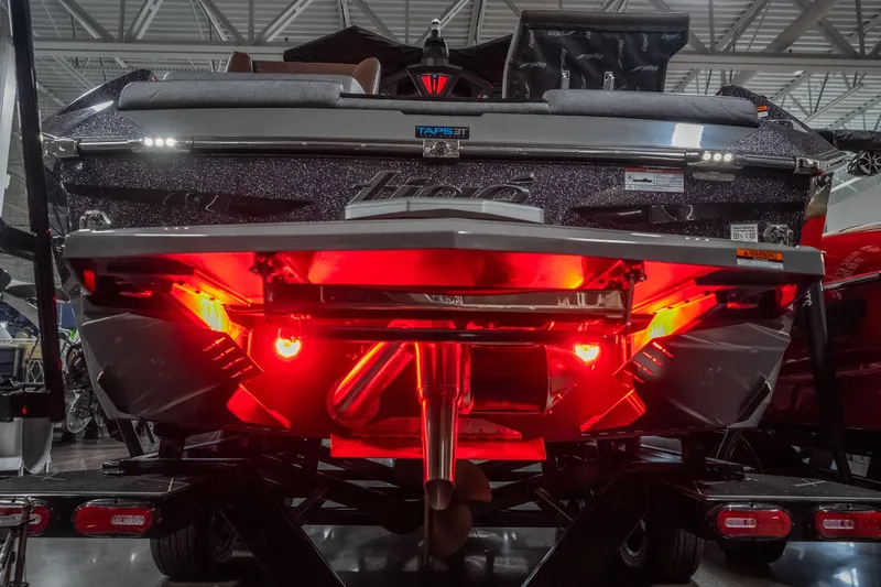 Slide: The Image of 2026 Tigé Ultré 25ZX boat rear view with vibrant red underglow lighting. - 4