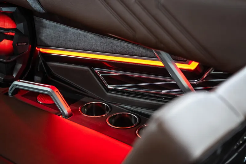 Slide: The Image of Interior of 2026 Tigé Ultré 25ZX boat with red ambient lighting and cup holders. - 31