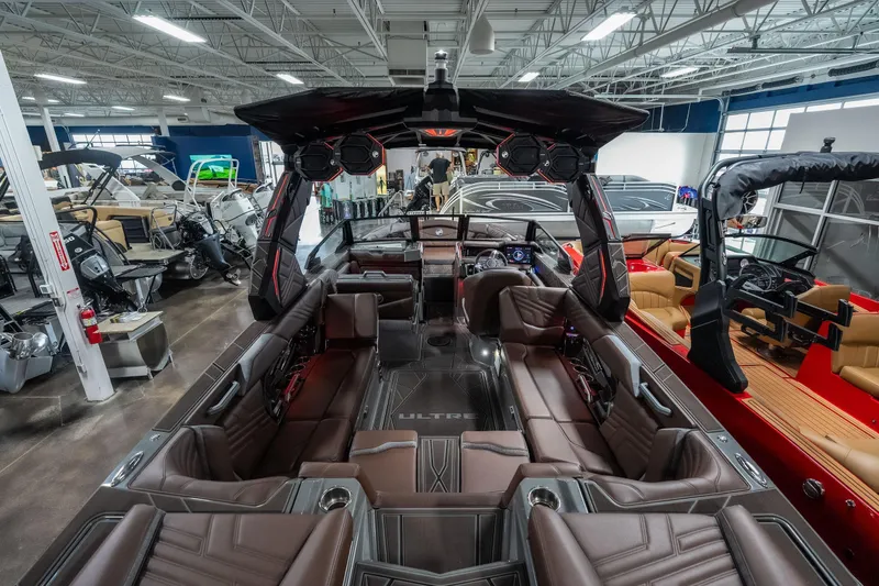 Slide: The Image of 2026 Tigé Ultré 25ZX luxury boat interior with brown seating in a showroom. - 7