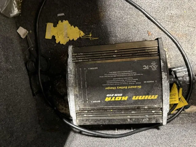 Slide: The Image of A Minn Kota on-board battery charger lies on the floor of a boat. - 23