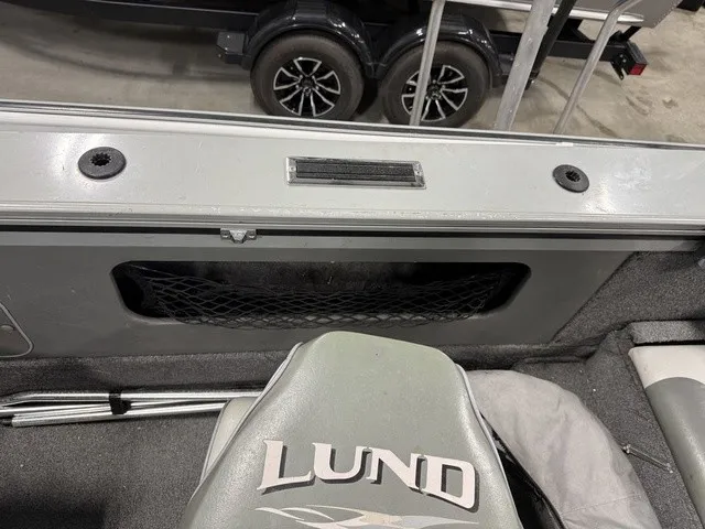 Slide: The Image of A gray seat with "Lund" printed on it in a boat, surrounded by metal railings. - 20