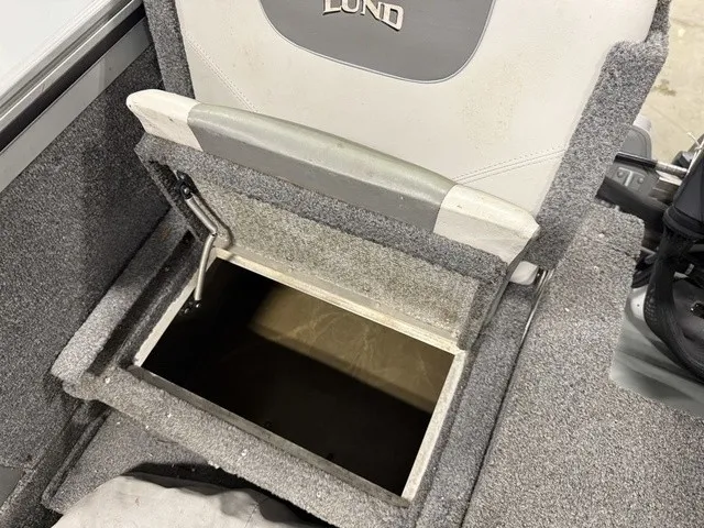 Slide: The Image of An open storage compartment in the floor of a boat with a Lund seat above. - 17