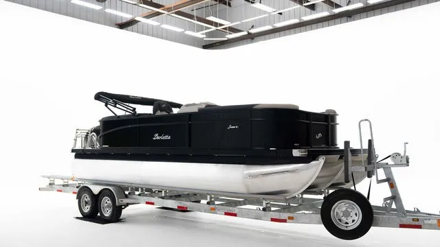 The Image of A 2027 Barletta S22QC pontoon boat on a trailer in a bright room. - 1