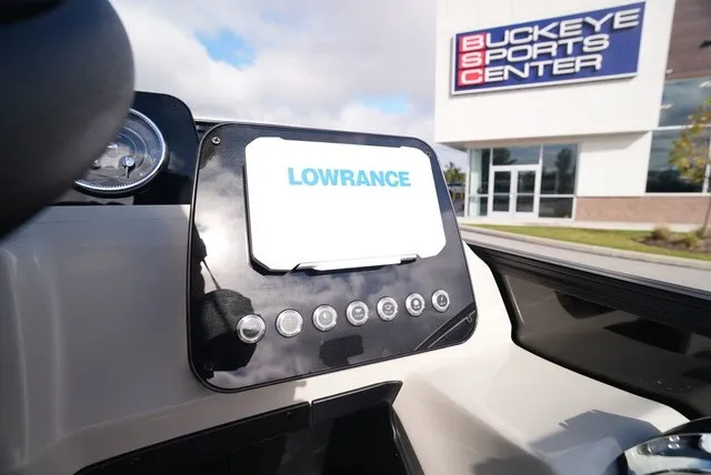 Slide: The Image of The dashboard of a boat with a Lowrance screen, taken in front of a sports center. - 22