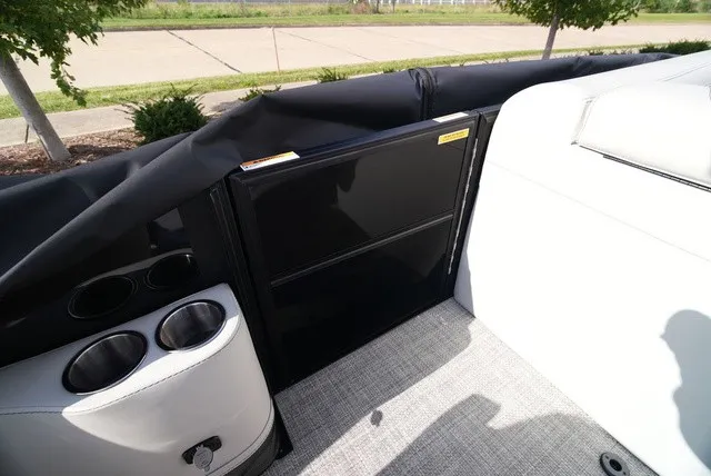 Slide: The Image of The image shows the interior of a Barletta A24UC boat with a black cabinet and cup holders. - 27