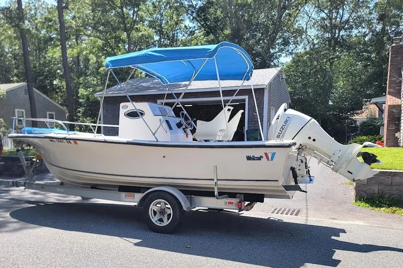 Slide: The Image of 1978 Wellcraft V-20 Steplift boat with blue canopy on trailer, parked outdoors. - 24