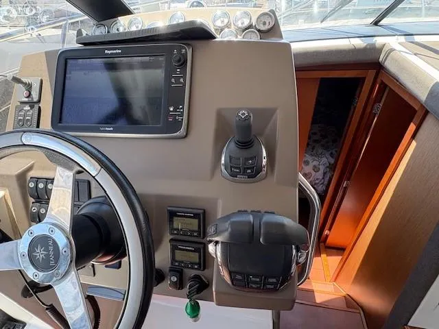 Slide: The Image of 2013 Jeanneau NC11 helm with navigation controls and steering wheel. - 10